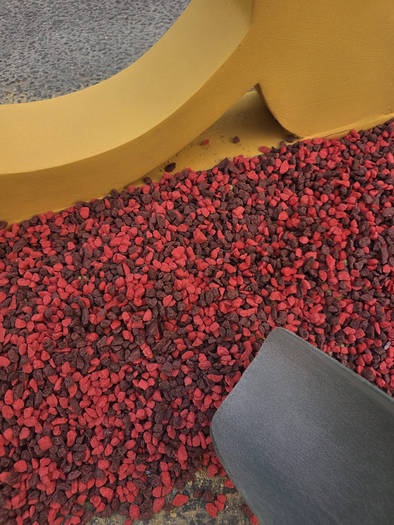 Detalle de la decoración de la Hoguera Grande Princesa Mercedes 2026, donde la combinación de piedra decorativa en tonos rojo y burdeos aporta contraste, profundidad y un mayor impacto visual, integrándose de forma natural con la temática de la obra.